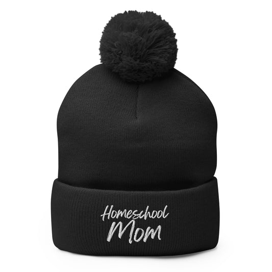 Homeschool Mom embroidered pom-pom beanie in classic knit style — cozy Christian winter hat by Morning Flora Devotionals.